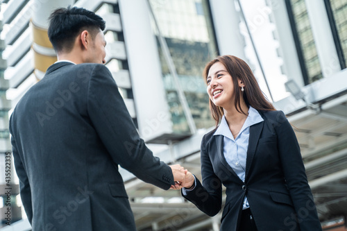Asian business people greeting by making handshake outdoor in the city