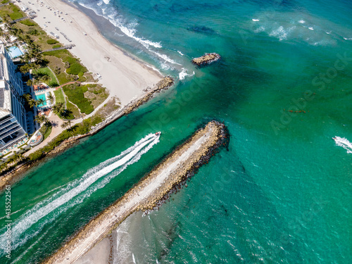Fototapeta Naklejka Na Ścianę i Meble -  aerial drone of boat heading out to ocean of Boca Raton Inlet, Florida