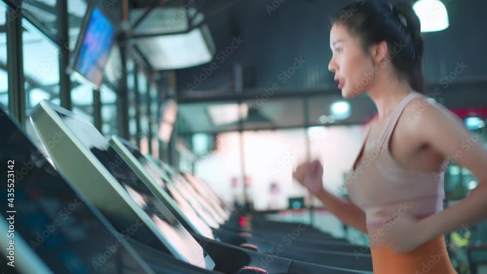 Asian female athlete doing exercise by running or walking on treadmill
