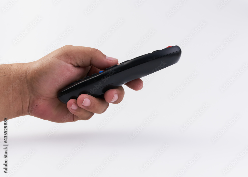 Mano de hombre sosteniendo un control remoto para televisión sobre un fondo blanco Mano de hombre sosteniendo un control remoto para televisión sobre un fondo blanco