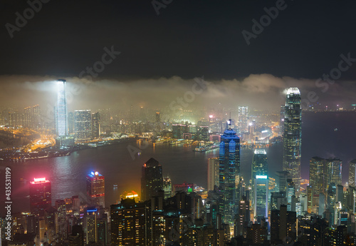 Misty night view of Victoria harbor of Hong Kong city in fog