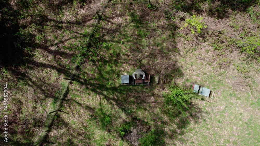 Bee Keeper checking bee hives shot from the air Bee Keeper checking bee hives shot from the air
