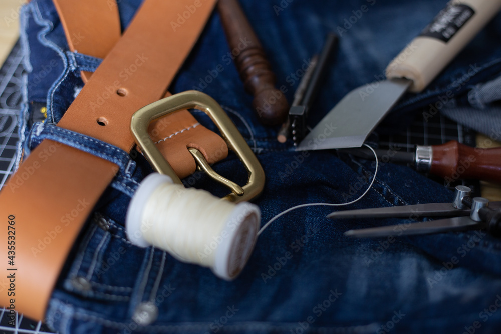 Leather belt brass buckle on jean pant