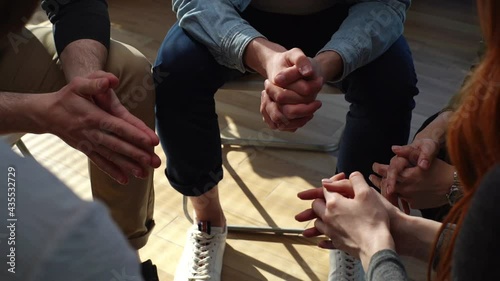 Close-up hands of unrecognizable multiethnic diverse men and women sitting in circle during group interpersonal therapy session. Tracking shot of people telling about his mental problem or addiction.