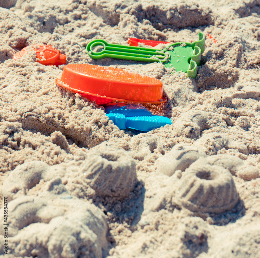 Different shapes made of sand and children toys for playing on beach. Vacation time and child development Different shapes made of sand and children toys for playing on beach. Vacation time and child development