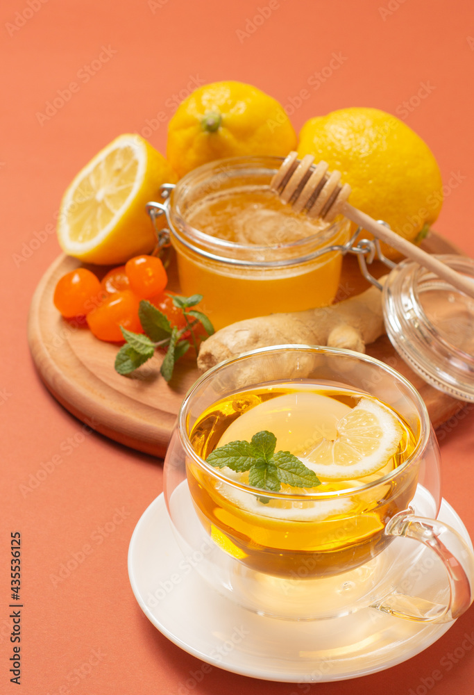 Ginger tea with mint and lemon. Healthy and hot drink. Liquid honey in honey-jar. Crystal cup on bright background. Selective focus. Ginger tea with mint and lemon. Healthy and hot drink. Liquid honey in honey-jar. Crystal cup on bright background. Selective focus.