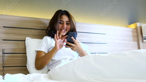 Young asian women lying in bed texting and checking social apps in smartphone on bed before after she sleeping at night. Mobile addict concept.