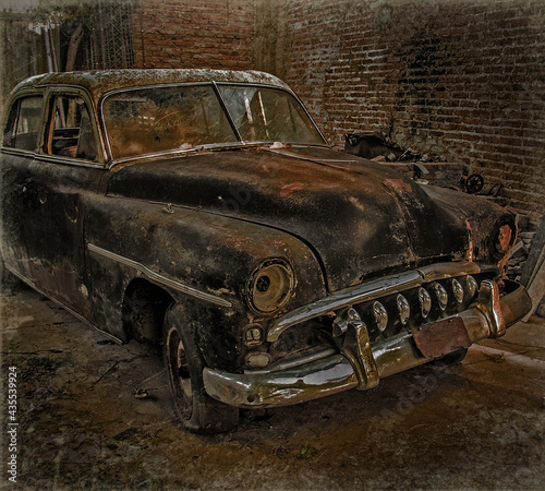 Photographic art of a destroyed, rusty and abandoned old car.
