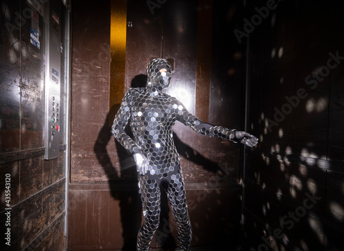 Sparkling discosuit man dancing in a lift