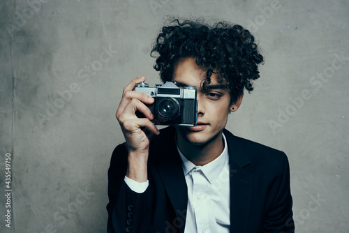 photographer with a camera in a classic suit curly hair Studio Model