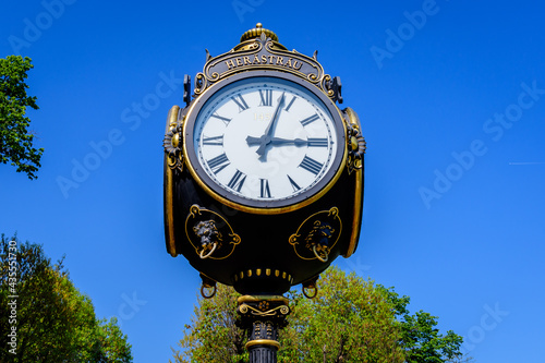 Vintage style black and grey metallic clock towards clear blue sky in King Michael I Park (former Herastrau) in Bucharest, Romania, in a sunny spring day.