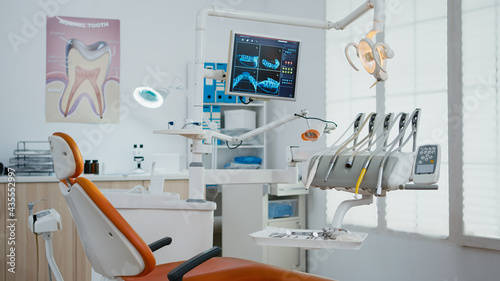 Fototapeta Naklejka Na Ścianę i Meble -  Interior of empty stomatology orthodontist office with nobody in it prepared for tooth surgery. Zoom in shot of teeth radiography on monitor. Orthodontic clinic with professional dentist equipment