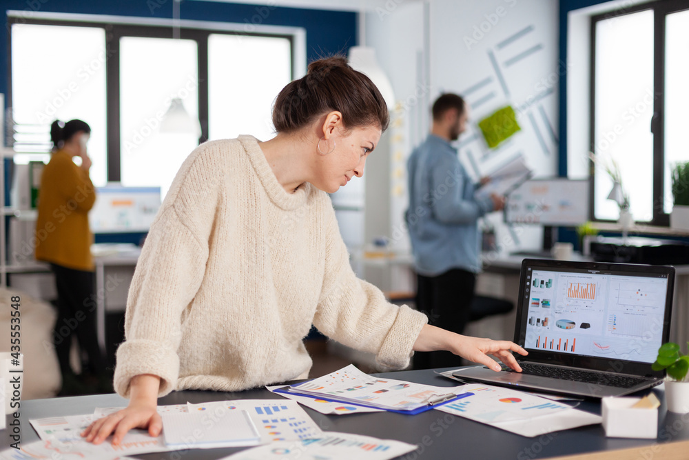 Αυτοκόλλητο Busy businesswoman employee concentrated on company charts scrolling on laptop