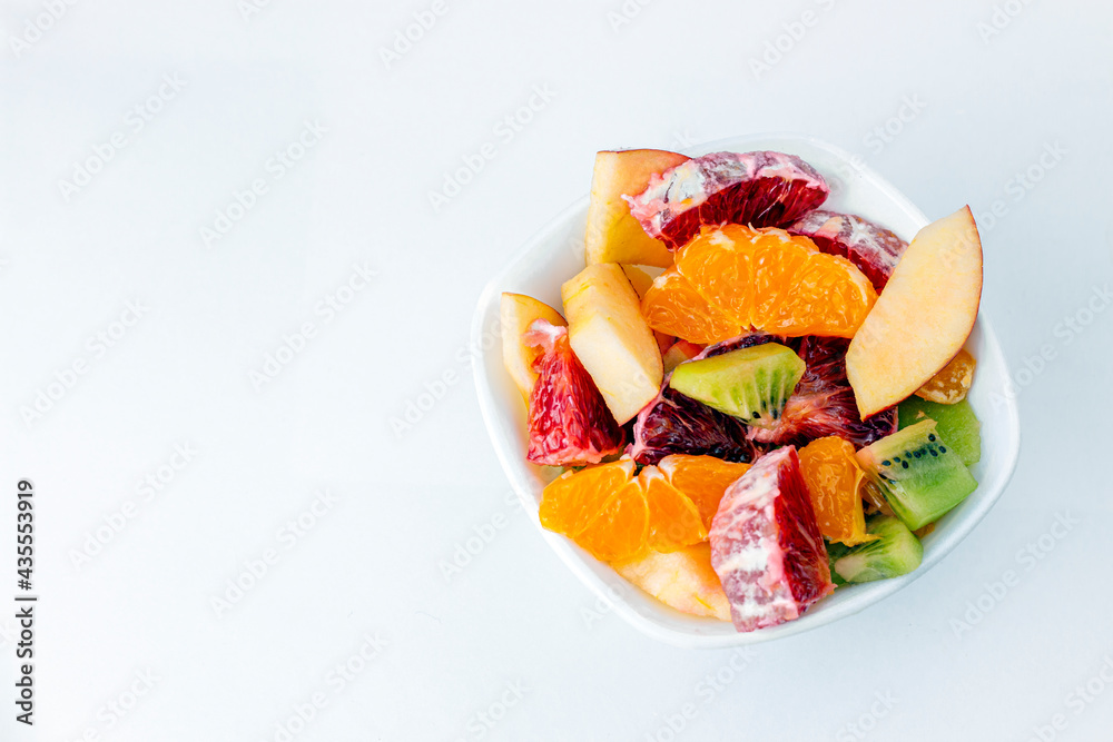 Fruit salad in ceramic bowl isolated on white background Delicious cut fruits close up background. Grapefruit, orange, kiwi and apple. Fruit salad in ceramic bowl isolated on white background Delicious cut fruits close up background. Grapefruit, orange, kiwi and apple.