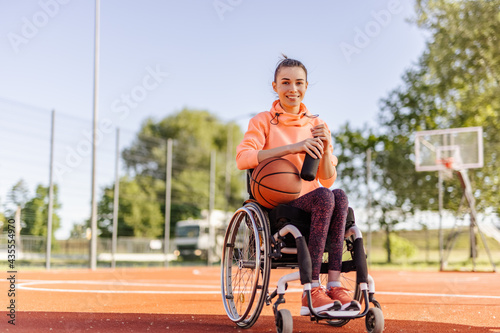 Positive girl, disability, basketball training, holding ball. © bnenin