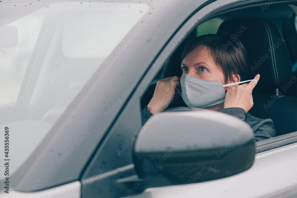 Woman wearing protective face mask in car during covid-19 pandemics Woman wearing protective face mask in car during covid-19 pandemics