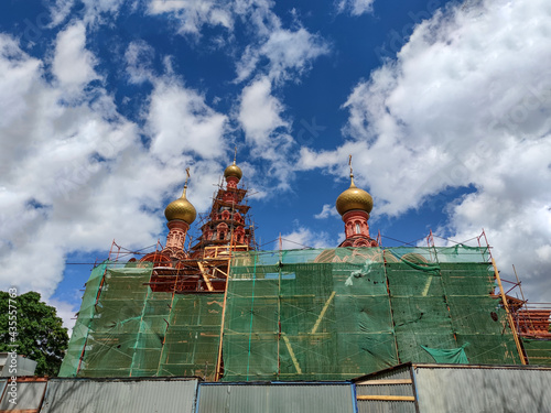 Church under restoration against the background of the sky and trees