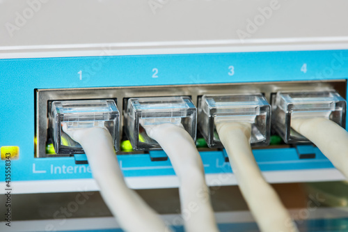 Ethernet cables connected to Desktop Switch or routerboard. Close-up, selective focus photo
