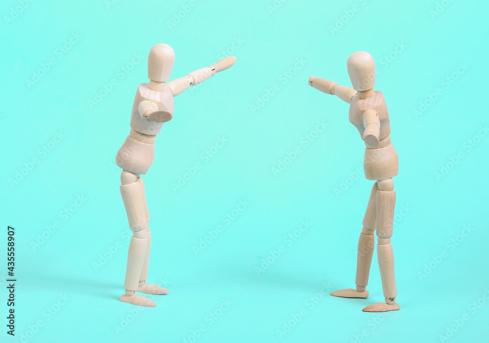 Two emotional wooden puppets on a blue background Two emotional wooden puppets on a blue background