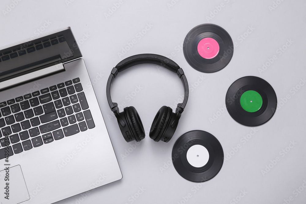 Laptop, Stereo headphones with vinyl records on white background. Laptop, Stereo headphones with vinyl records on white background.