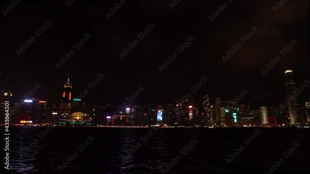 Laser light show on the embankment in Hong Kong on the Avenue of Stars. Multi-storey buildings are glowing and reflecting in the water Laser light show on the embankment in Hong Kong on the Avenue of Stars. Multi-storey buildings are glowing and reflecting in the water