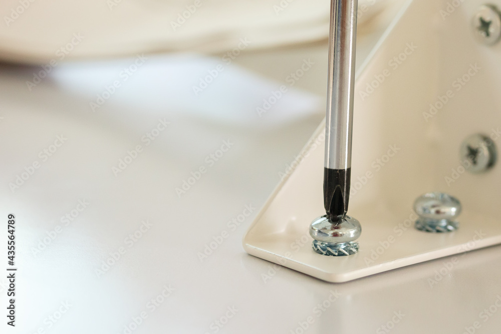Asian man assembling white table furniture at home Asian man assembling white table furniture at home