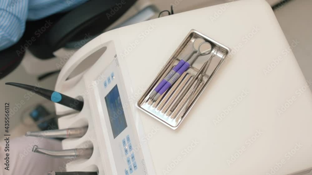 doctor's hands open the package with sterile instruments for work. She begins to examine the patient's teeth. Dental treatment. Gloved hands. doctor's hands open the package with sterile instruments for work. She begins to examine the patient's teeth. Dental treatment. Gloved hands.