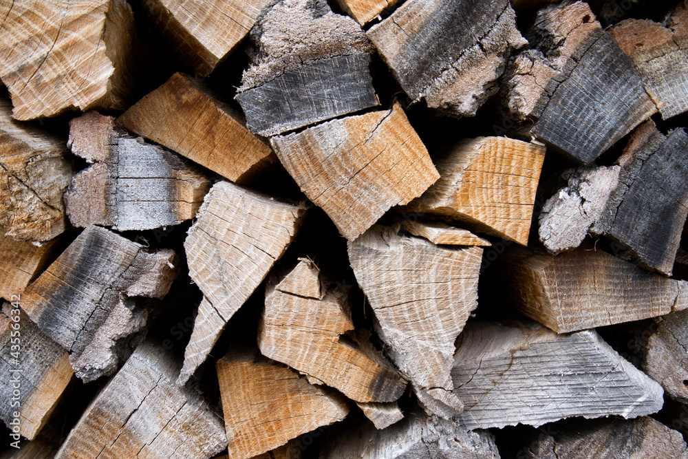 Large pile of firewood, cut of wood, dark texture group of objects close up Large pile of firewood, cut of wood, dark texture group of objects close up