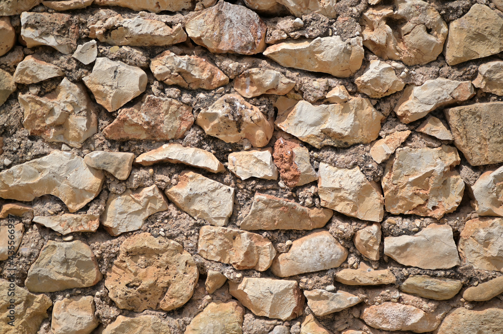 A traditional brown natural stone wall in Spain.