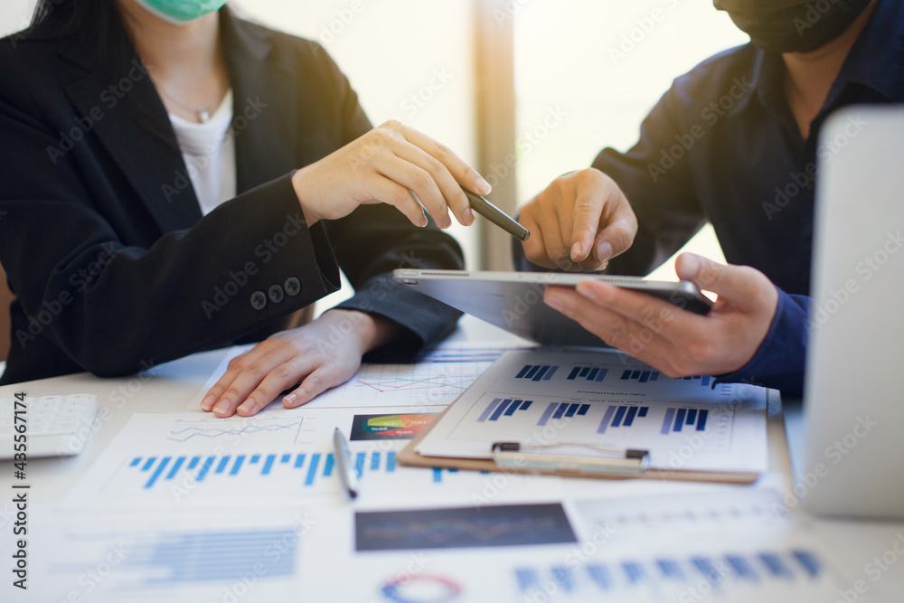Fototapeta premium Business people discuss charts and graphs showing the results of successful teamwork. Use graph sheets and tablets to work.