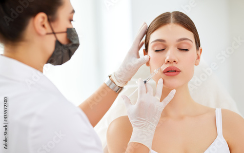 Woman getting beauty injection in salon