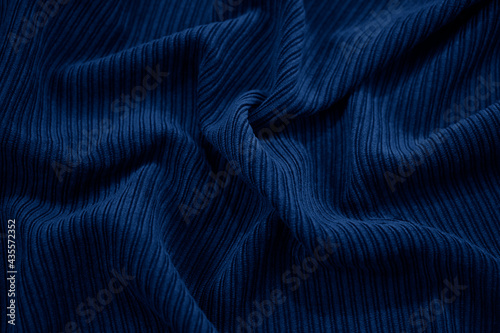 Navy blue volumetric abstract background. Corduroy fabric with soft wavy folds. Elegant background with copy space for design. Web banner.