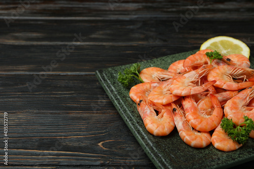 Plate with tasty shrimps on wooden background
