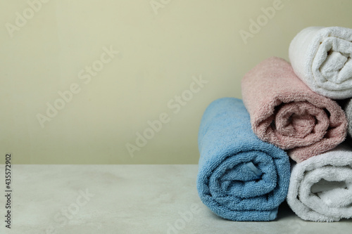 Clean rolled towels against beige background, space for text
