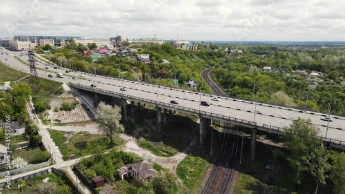 traffic of cars over the bridge with railway tracks. aerial shooting photo