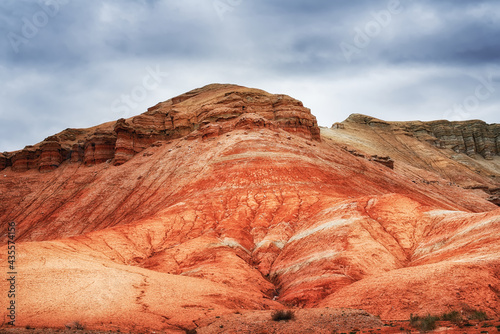 The hill is red yellow and white clay  ancient multi-colored deposits. Geology  erosion  soil layers. View of the Altyn-Emel park in Kazakhstan
