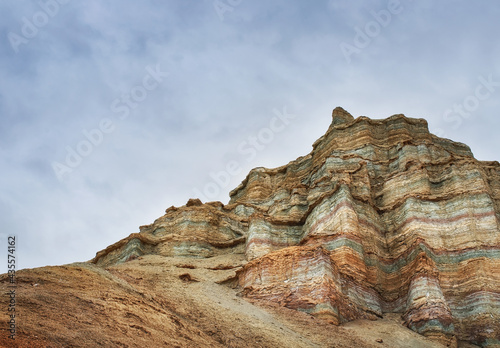 Rocky cliffs of multi-colored rocks, a canyon among the ancient desert steppe fields, geological deposits of different times, clay, erosion, stones. Cliffs, hills in the Altyn-Emel. Kazakhstan