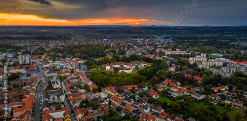 Sarvar, Hungary - Aerial panoramic view of the Castle of Sarvar (Nadasdy castle) with Sarvar Arboretum, a beautiful dramatic sunrise and rain clouds at background on a calm autumn morning