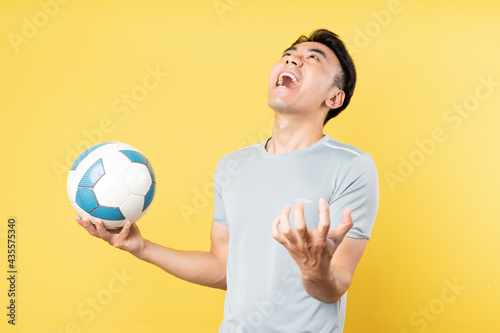 Asian man holding ball in hand and screaming