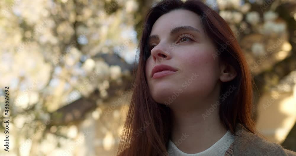 Portrait of young European Woman standing outdoor enjoys nature looking ahead. Having a natural, clean pretty face and long brown hair. Pretty appearance. Spring Lady. Happy millennial. Portrait of young European Woman standing outdoor enjoys nature looking ahead. Having a natural, clean pretty face and long brown hair. Pretty appearance. Spring Lady. Happy millennial.
