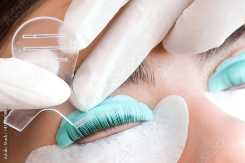 Young woman doing eyelash lamination procedure in a beauty salon