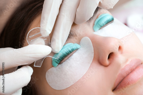 Young woman doing eyelash lamination procedure in a beauty salon photo