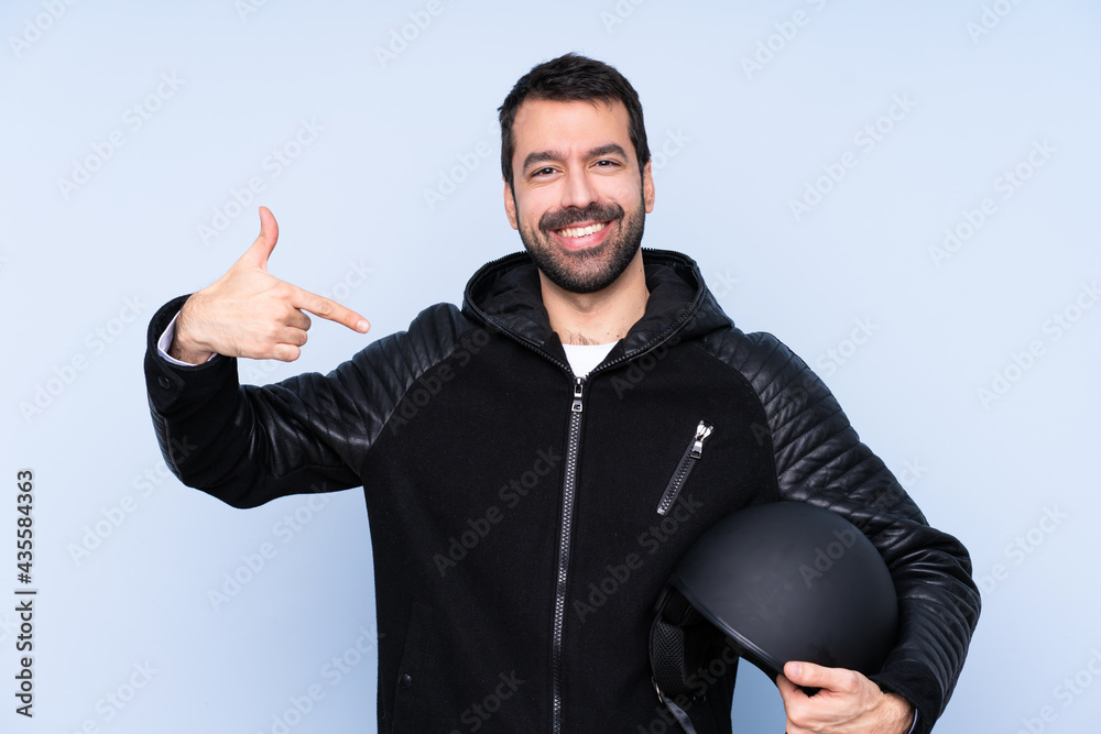 Naklejka premium Man with a motorcycle helmet over isolated background proud and self-satisfied