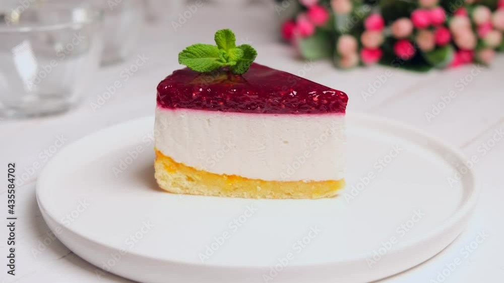 a piece of raspberry cake or cheesecake on a white plate garnished with mint a piece of raspberry cake or cheesecake on a white plate garnished with mint