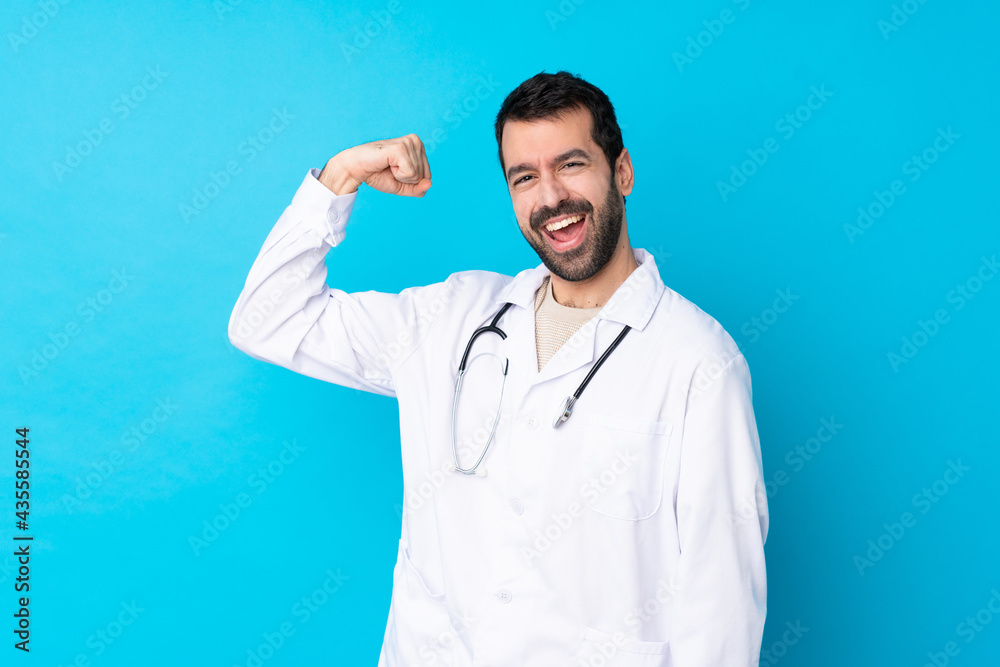 Young caucasian man over isolated background wearing a doctor gown and making strong gesture Young caucasian man over isolated background wearing a doctor gown and making strong gesture
