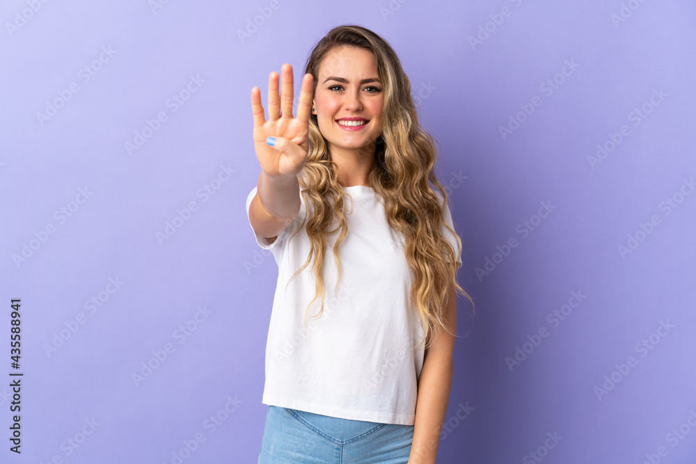 Fototapeta premium Young Brazilian woman isolated on purple background happy and counting four with fingers