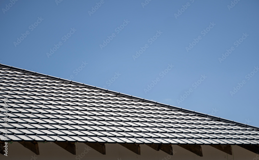 Brown corrugated metal profile roof installed on a modern house. The roof of corrugated sheet. Roofing of metal profile wavy shape. Modern roof made of metal. Metal roofing.