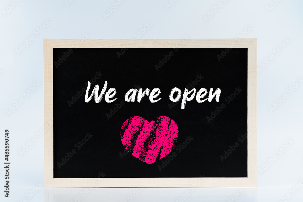 We are open chalkboard sign with a chalk heart. Post lockdown reopening