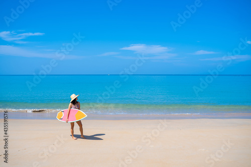 girl with surfboard on the beach