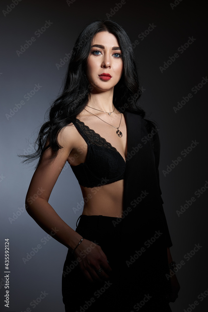 Sexy beauty brunette woman in black jacket poses in studio. Elegant girl with beautiful natural makeup Sexy beauty brunette woman in black jacket poses in studio. Elegant girl with beautiful natural makeup